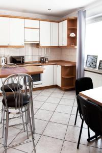 波兹南Miastkovo的厨房配有白色橱柜和桌椅