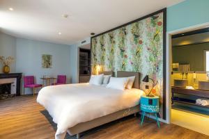 日内瓦Marmont Hotel的一间卧室设有一张大床和大型花卉墙