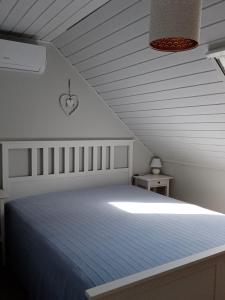 BadacsonyBalcsiHáz Badacsony的白色卧室配有一张带蓝色毯子的床