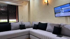 马拉喀什Dar laabi的客厅配有带黑色枕头的白色沙发