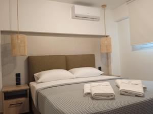 帕莱罗斯Q Luxury Rooms Paleros的一间卧室配有一张床,上面有两条毛巾