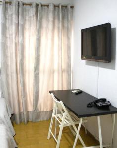 奇克拉纳－德拉弗龙特拉维拉别墅旅馆的一间房间,墙上有桌子和电视