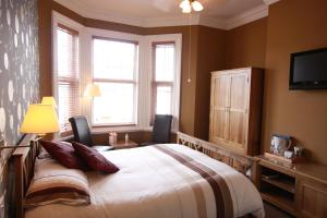 约克布伦特伍德宾馆的一间卧室配有一张带两把椅子的床和电视。
