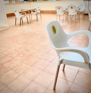 萨洛RoNi RoOms的配有桌椅的房间的白色椅子