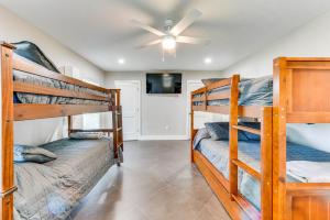 查尔斯湖Luxe Lake Charles Escape with Home Theater!的一间卧室设有两张双层床和吊扇