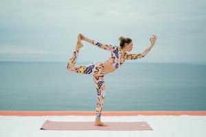 伊斯基亚Hotel Villa Maria的一名在海滩上做瑜伽姿势的女人