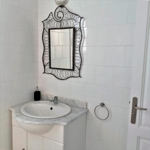 杰尔吉斯VILLA KIKA ZARZIS, LOCATION CHAMBRES D'HÔTES en TUNISIE的白色的浴室设有水槽和镜子