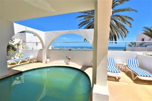 杰尔吉斯VILLA KIKA ZARZIS, LOCATION CHAMBRES D'HÔTES en TUNISIE的一个带椅子的游泳池,享有海景