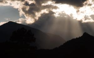 埃斯蒂斯帕克McGregor Mountain Lodge的阳光从云中穿过高山