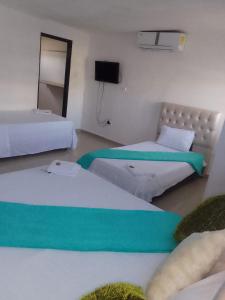 巴兰基亚buenavista class的一间设有两张床和电视的房间