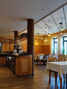 德根多夫Stadthotel Deggendorf的一间带桌椅的餐厅和一间厨房
