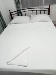 独鲁万Viner's Inn的一张带黑色框架和白色枕头的白色床