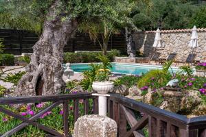 Káto YerakaríonArt House Villa的一座花园,花园内种有树木,并设有一个游泳池
