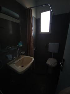 希俄斯Omiros rooms的一间带水槽、窗户和卫生间的浴室