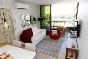 埃斯特城Cielo Ejecutivo: Un hogar en la ciudad的客厅配有白色沙发和红色椅子