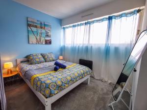 锡耶Léman Holidays - Le Blue Sky的一间卧室配有一张蓝色墙壁的床和一扇窗户