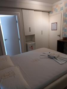 阿瓜斯克拉腊斯Hotel 1001 Prime Ade Águas Claras的卧室配有白色床和毛巾