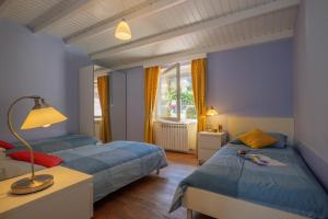 科利科Casa del Sole的蓝色墙壁客房的两张床