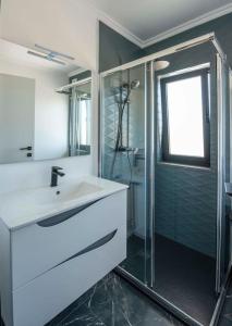 维拉多比斯坡Sunset House的一间带水槽和玻璃淋浴的浴室