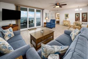 沃尔顿堡滩Nautilus 1702 Gulf Front Large 2 Bedroom Penthouse 7th Floor的客厅配有蓝色的沙发和平面电视。