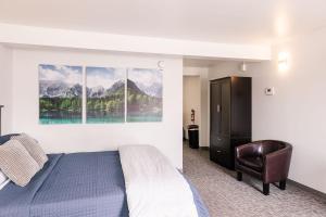 Delta JunctionAlaska Frontier Inn的一间带床和椅子的卧室,享有山景