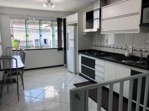伊达贾伊Casa Sérgio的厨房配有白色橱柜、桌子和用餐室。