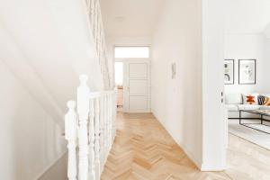 汉堡Villa im Alten Land Hamburg - für große Gruppen的白色的走廊,设有白色的楼梯和白色的沙发