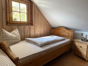 SchmogrowWalnußhof的一间卧室设有一张木床和一个窗户。
