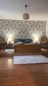 BiałlaAgro na Wapniarni的一间卧室配有一张带花卉壁纸的大床