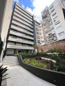 布宜诺斯艾利斯Barrancas Quality Apartments的公寓大楼前方设有花园