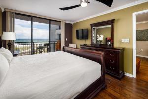 沃尔顿堡滩Nautilus 2407 Gulf View 2 Bedroom 4th Floor Free Beach Service的一间卧室配有一张床、一台电视和一个阳台