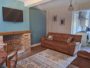 RocesterCosy cottage near Alton Towers的带沙发和壁炉的客厅