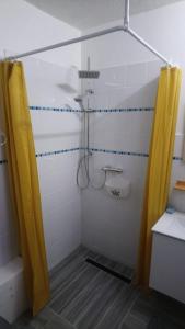 巴斯特尔Chez Caroline的浴室设有黄色淋浴帘和淋浴