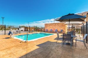 科珀斯克里斯蒂Fairfield Inn & Suites by Marriott Corpus Christi Central的一个带桌椅和遮阳伞的游泳池