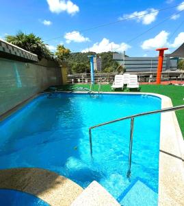 巴拿马城卡萨米勒酒店的一个带两把白色椅子的大型蓝色游泳池