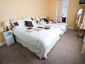 瑟勒斯Hawthorn View Bed and Breakfast的一间卧室配有两张带白色床单和镜子的床