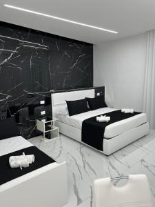 卡塞塔White Elegance Luxury B&B Caserta的一间卧室设有两张床和大理石墙
