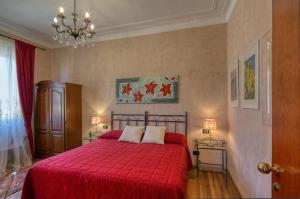 热那亚梦德娜洛坎达别墅酒店的一间卧室配有一张带红毯和吊灯的床。