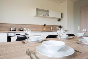 斯塔勒斯普拉维Apartmán v LakeParku的厨房配有木桌、盘子和酒杯