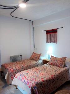 马德普拉塔Hotel Medina B&B的一间卧室设有两张床、一个窗口和一盏灯。