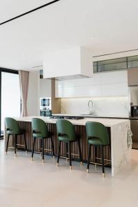 伊察Luxury House Buena vista的厨房配有绿色椅子,环绕着厨房柜台