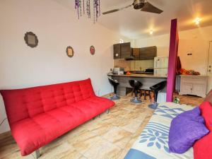 赛姆Dep 304a En Casablanca Linda Suite Petfriendly cerca de todo的客厅里设有一张红色的沙发,配有厨房