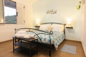 卡尔德杜Agriturismo Sa Jana Holidays - Adults Only的一间卧室配有一张床、一张桌子和一个窗户。