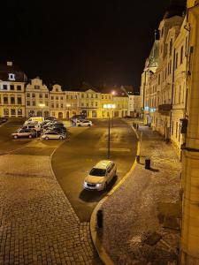 赫拉德茨 - 克拉洛韦Podkrovní byt na Velkém náměstí s Wi-Fi zdarma的一群晚上停在停车场的汽车