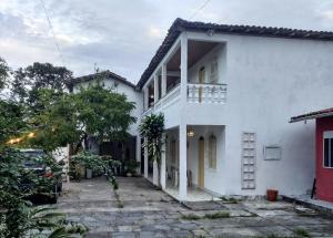 塞古罗港Pousada Sonho Meu的带阳台和车道的白色房屋