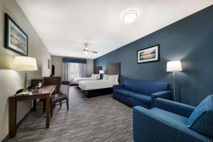 Lake Dallas达拉斯湖贝斯特韦斯特酒店的酒店客房配有一张床、一张沙发和椅子。