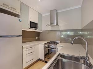 伊登伊格高地假日酒店的厨房配有白色橱柜和不锈钢盥洗盆