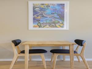 伊登伊格高地假日酒店的一张桌子、两把椅子和墙上的一幅画