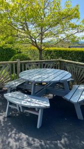 格伦加里夫Hill Sea View Cottage的木栅栏旁的野餐桌和长凳