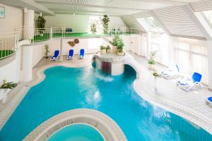 戈斯拉尔阿施特曼酒店的一座带蓝色椅子的建筑中的游泳池